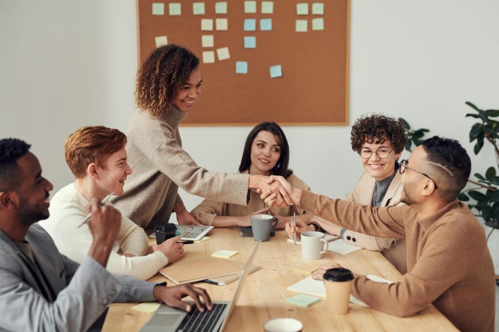 Team of professionals shaking hands in a modern office meeting, representing the rise of Smart businesses in 2026 and collaborative growth strategies.